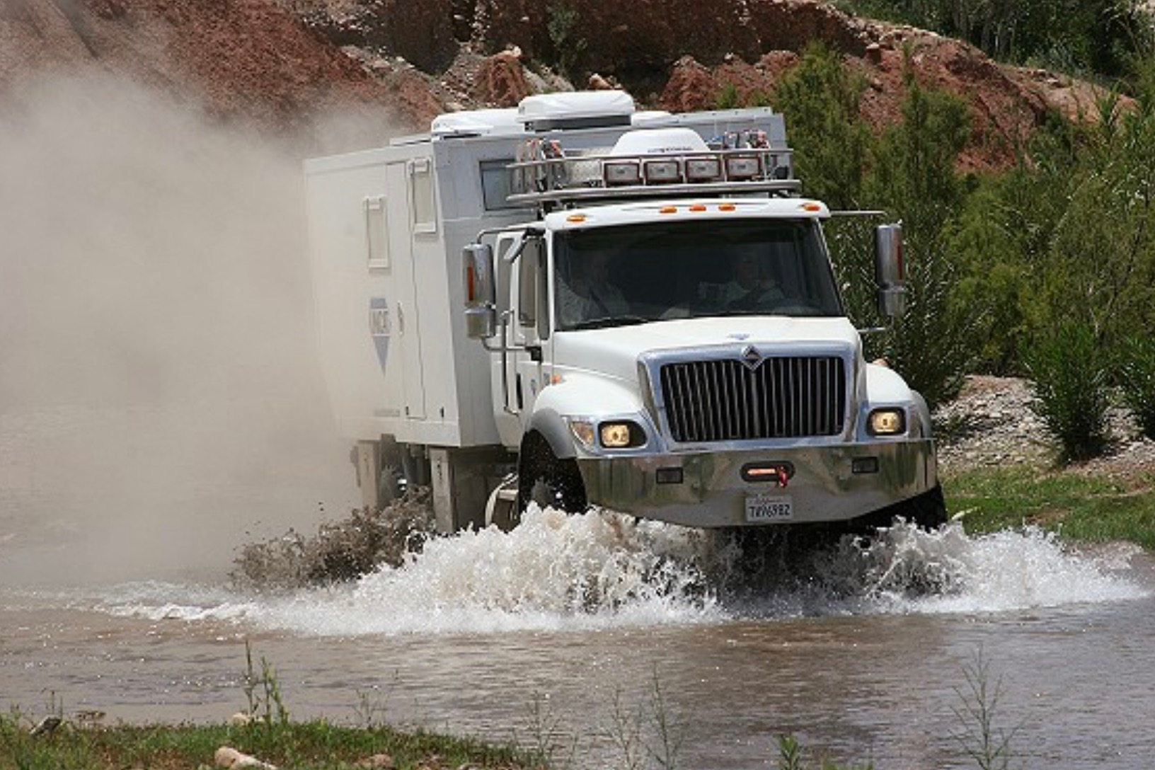 UNICAT expedition vehicle crossing water in desert terrain